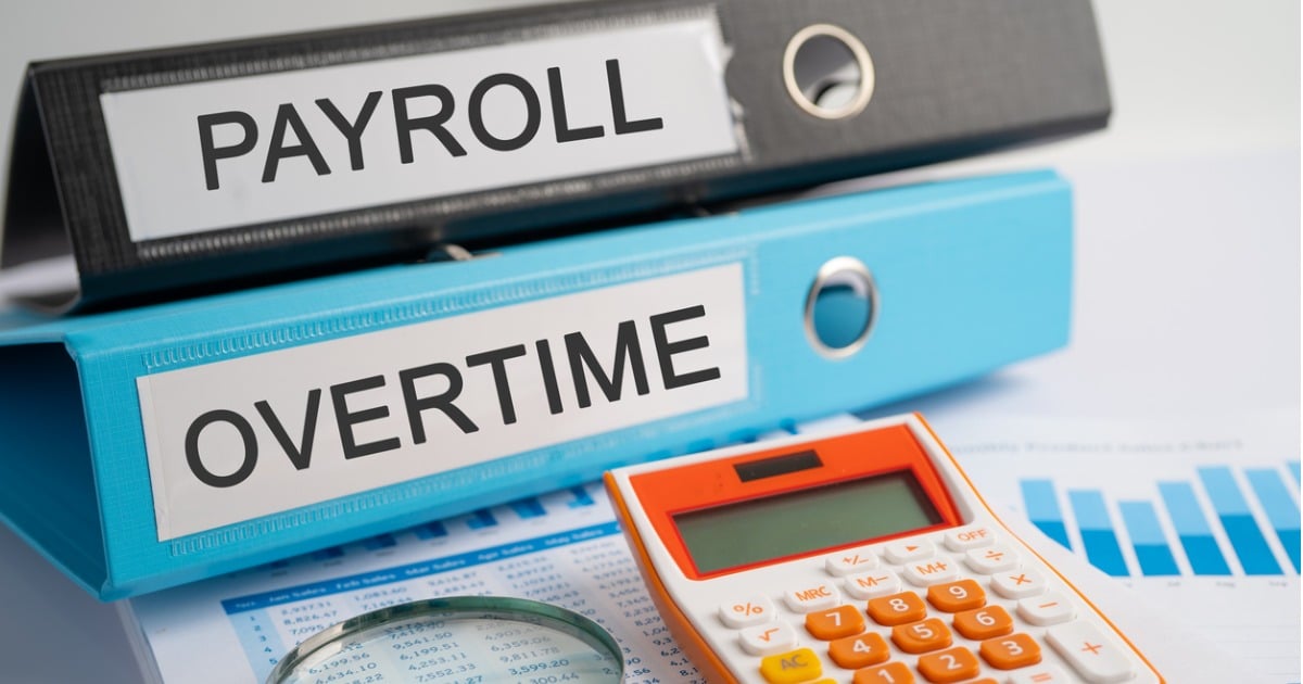 The spines of two big binders read "Payroll" and "Overtime"